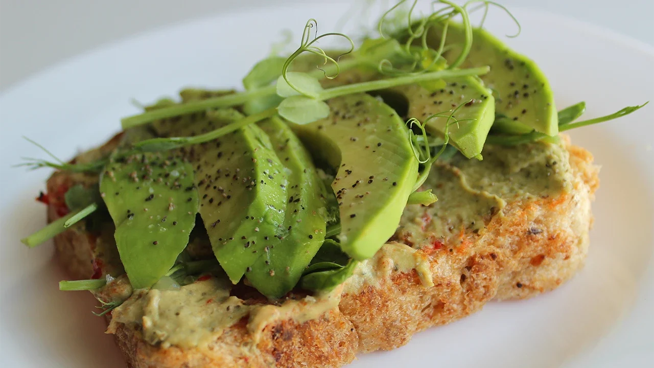 yeast-free-toast-with-sliced-spicy-avocado-peas-grass-white-plate